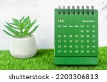 Green December 2022 Monthly desk calendar for 2022 year on grass.