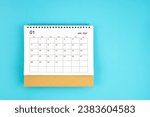 Small photo of January 2024, Monthly desk calendar for 2024 year on blue color background.