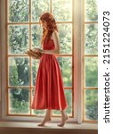 Small photo of Medieval woman princess holds in hands reads book. Red-haired dreamlike girl stands on window barefoot, view summer green garden trees. Red vintage dress, ball gown. Long red curly hair, pale skin