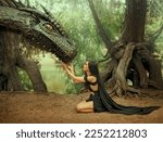 Small photo of Fantasy woman elf queen touching with hands dragon head. Girl mistress tamed monster concept female power. black creative dress, girl princess fashion model sits on knees. Deep green forest trees.