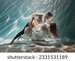 Small photo of Real People art photo. Happy couple in love swim underwater, woman muse inspires male writer poet creator. Nymph girl dancing with guy at bottom sea under water. Red hair white long silk dress float.