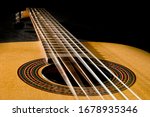 Classical guitar with vibrating strings on a black background