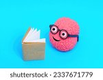 Cute human brain character wearing glasses, wholeheartedly immersed in a book. Pleasure of discovering new ideas.