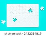 Small photo of Blank white rectangular puzzle with two final pieces set aside on a serene blue background. Challenge and creativity related concept.