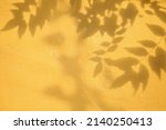 Shadow of leaves on yellow concrete wall texture with roughness and irregularities. Abstract trendy colored nature concept background. Copy space for text overlay, poster mockup flat lay 