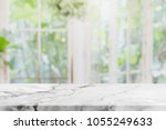 Empty white stone marble table top and blurred of interior room with window view green from tree garden background background - can used for display or montage your products.