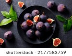 Fresh figs on black plate. Dark background. Close up. Top view.