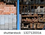 Construction building materials and industrial supplies such as bricks, woods and pipes stacked and arranged for sale at a hardware store front.