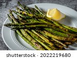 Grilled asparagus on white serving dish.