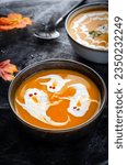 Small photo of Pumpkin Soup, Halloween Cream Soup on Dark Cobweb Decorated Background