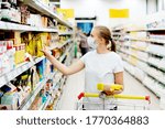 Small photo of A masked woman during a pandemic is shopping at the supermarket. Countervailing measures in pandemic. Grocery shopping.
