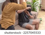 Small photo of A battered husband defends himself from being hit by his abusive and violent wife. Physical abuse, domestic violence and toxic relationship.
