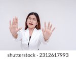 Small photo of A terrified woman under duress pleads at someone to please stop. Isolated at a white background.