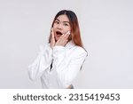 Small photo of An appalled and surprised young woman holding her face with both hands in shock. Isolated on a white background.