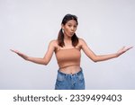 Small photo of A young asian woman expressing something large by outstretching her arms, conveying something large. Looking impressed or astounded. Isolated on a white background.