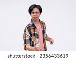 Small photo of A vindicated young asian man celebrating, pumping his fist. Feeling amped and stoked. Isolated on a white background.