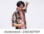 Small photo of A vindicated young asian man celebrating, grooving and jiving. Feeling amped and stoked. Isolated on a white background.
