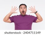 Small photo of A shocked and surprised man put his hands up on instinct after a jump scare moment. Wearing a purple waffle shirt. Isolated on a white background.