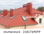 A modern new building with a red tiled roof. Ventilation pipes protrude from the newly renovated roof. An office building for doing business.