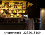 Small photo of Minsk, Belarus June 22, 2022: A bar counter in a restaurant with low lighting. Bottles of expensive alcohol are on the shelves in the bar. A cozy night place.