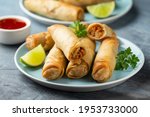 Fried spring rolls with sweet chili sauce and lime on plate