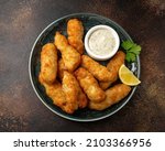 Small photo of Crispy Fish strips with tartar sauce in a plate