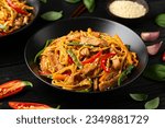 Small photo of Stir fry chow mein noodles with pork and vegetable in black bowl. asian style food