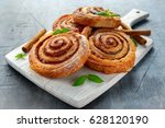 Freshly Baked Traditional Sweet Cinnamon Rolls, Swirl on white wooden board.