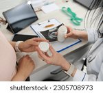 Overhead view of doctor gynecologist obstetrician prescribing prenatal vitamins and nutritional supplement to a pregnant woman in a gynecological clinic. Pregnancy. Maternity. Healthcare and medicine