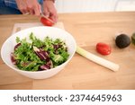 Small photo of Close-up hands of a male chef chopping ripe organic tomatoes while preparing a delicious healthy salad from fresh vegetables and herbs. People. Food. Healthy eating, alimentation and dieting concept