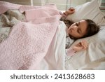 Small photo of Authentic portrait of Caucasian elementary age, a cute little kid girl seeing sweet dreams while sleeping on the bed with comfortable mattress. Bedtime. Bedchamber furniture. Happy carefree childhood