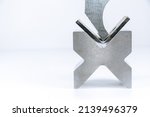 Small photo of Sheet metal bending tool and equipment isolated on a white background. Bend tools, press brake punch and die. Bending tool isolated on a white background. Close up.