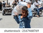 Small photo of Palestinians receive food rations from the United Nations Relief and Works Agency (UNRWA) warehouse the Khan Yunis refugee camp in the southern Gaza Strip, on June 14, 2022.