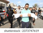 Small photo of Palestinians carry the body of a 3-year-old child, Amir Qanan, who was killed after an Israeli air strike on his home, in the city of Khan Yunis, southern of the Gaza Strip, on October 10 2023.