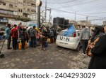 Small photo of Palestinians distribute drinking water to owners of demolished homes and displaced people from Gaza City, on December 23, 2023.