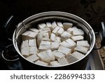 Small photo of stalked white tofu in a stainless steel pot. Tofu is a food made from the coagulation of coagulated soy bean juice. Tofu originates from China. Tahu.
