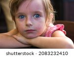 Small photo of Portrait of a beautiful little girl child with reddened face and tired sad expression, feeling unwell in case of allergic reaction