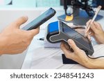 Close-up of a customer holding his smartphone paying using nfc technology, card reader machine for the customer to make the payment transaction with the contactless method. . High quality photo