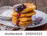 Stack of pancakes with jam and sugar