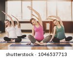 Group of young pregnant women are doing relaxation exercise on exercise mat