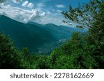 Cloudy mountain landscape. The gorge of the Caucasus mountains, with a small village below. tourist destinations. incredible landscape. mountainous terrain with lush vegetation and misty mountain tops