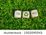 Cubes and dice in the green grass with zero waste and recycling logo