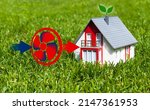 Small photo of Miniature house in the grass with air heating pump or air heat pump