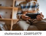 Small photo of hand of boy caucasian child hold smartphone mobile phone at home play video games childhood and growing up technology addiction concept use smartphone app for online browsing or watch video