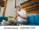 Small photo of One senior man caucasian male grandfather sit at home take drug tablet drink painkillers or vitamin supplement read label medicine real person health and medicine concept copy space