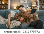 Adult couple man and woman Caucasian husband and wife in a relationship real book hold books on the sofa bed at home in the apartment reading leisure bonding family concept real people copy space