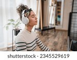 Small photo of one woman adult caucasian female millennial using headphones for online guided meditation practicing mindfulness yoga with eyes closed on the floor at home real people self care concept copy space
