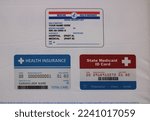 Small photo of Charlotte, NC, USA-November 18, 2022: Medicaid and health insurance card examples posted to inform the public regarding benefits they may be eligible for
