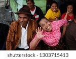 Small photo of Berastagi, Sumatra - January 26, 2018: very cheerful laughing and fumbling Indonesian elderly woman in a pink blouse and her stylishly dressed man in a brown hat
