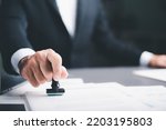 Small photo of business people stamp On the contract documents at the desk, the concept of confirmation or approval of the agreement, the application authorization authority, the bank loan documents through support.